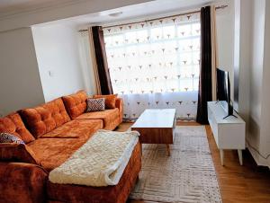 a living room with a couch and a tv at Cosmic home in Thika