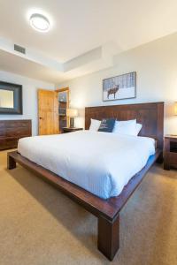 Serene 3BR Rockies Stay with Hot Tub and Near DT في كانمور: غرفة نوم كبيرة مع سرير كبير مع ملاءات بيضاء