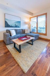 Serene 3BR Rockies Stay with Hot Tub and Near DT في كانمور: غرفة معيشة مع أريكة وطاولة قهوة