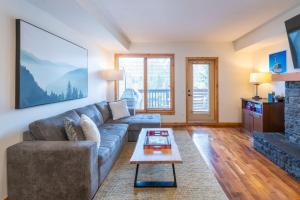 Serene 3BR Rockies Stay with Hot Tub and Near DT في كانمور: غرفة معيشة بها أريكة وطاولة +28 صورة