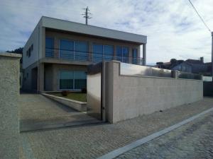 een gebouw met een muur en een hek ervoor bij Casa Do Chino in Outeiro