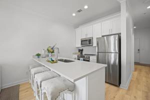 a kitchen with white cabinets and a stainless steel refrigerator at Extended Stay Friendly-Full Kitchen & Laundry in Pass Christian