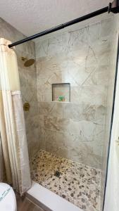 a shower with a glass door in a bathroom at Waterfront home with Firepit and Foosball Table in Fruitland Park +25 photos