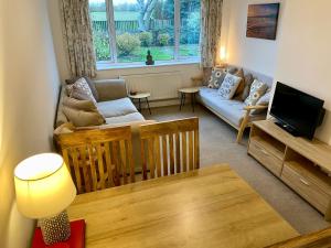 een woonkamer met een bank en een tv bij Simla Bungalow, Tetney in Tetney