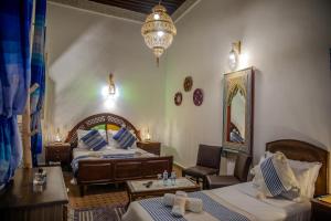 a hotel room with two beds and a chandelier at Riad Dar Bahja - More Than a Stay in Fès