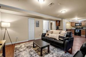 a living room with a black leather couch and a table at Spacious 3 bed 3 bath Apartment No stairs in Buffalo