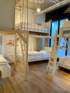 a room with three bunk beds and a ladder at Minimal Hostel Kreuzberg in Berlin