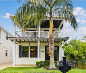 een palmboom voor een wit huis bij Downtown Sarasota 4 Unit Compound- Beach Shopping Park in Sarasota