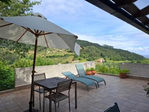 a patio with a table and chairs and an umbrella at La Pabla in Colunga