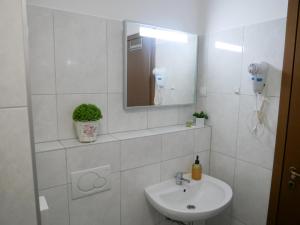 ein weißes Badezimmer mit Waschbecken und Spiegel in der Unterkunft Queen's gate in Zagreb