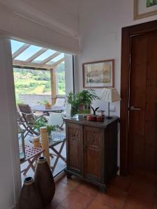 a living room with a table with a lamp and a patio at La Pabla in Colunga