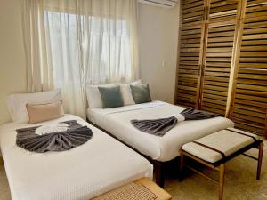 two twin beds in a room with a window at Villa Palmera in Las Terrenas +22 photos