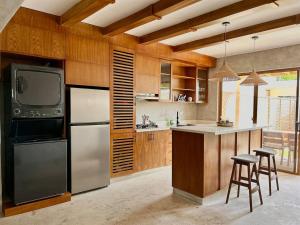 a kitchen with a refrigerator and a tv on the wall at Villa Palmera in Las Terrenas