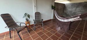 マリンガにあるDoce larの椅子が2脚とネットが張られた壁がある部屋