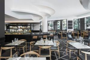 Opulent one bedroom apartment in parramatta. في سيدني: مطعم به طاولات وكراسي وبار