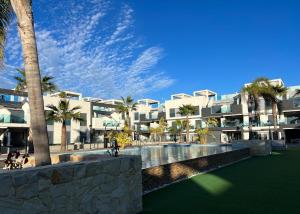 a resort with a swimming pool and palm trees at Flamingo del Guardamar in Guardamar del Segura