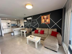 a living room with a couch and tables and a kitchen at Flamingo del Guardamar in Guardamar del Segura