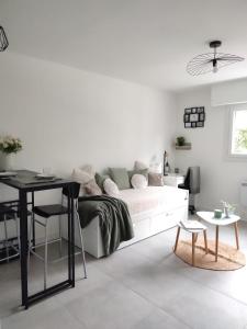 ein weißes Schlafzimmer mit einem Bett und einem Schreibtisch in der Unterkunft Studio Cosy, résidence sécurisée, parking privé in Pau