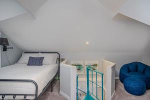 ein Schlafzimmer mit einem Bett und einem blauen Stuhl in der Unterkunft Center Lake Cape Cod Escape Family Waterfront Home with Dock Scenic Views and Pet Friendly in Salem