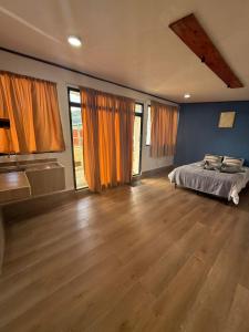 a bedroom with a bed and a wooden floor at Green haven Poas in Poasito