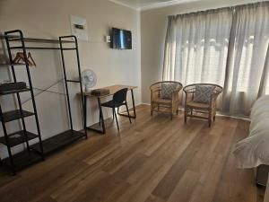 una camera da letto con un letto, una scrivania e delle sedie di West Coast Beachfront a Velddrif Altre 8 foto