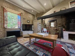 Saint-Paul-la-RocheDemeure XIXᵉ avec rivière en Dordogne, piscine et wifi - FR-1-839-11的带沙发和壁炉的客厅