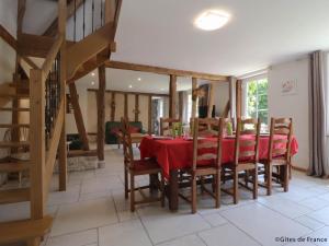 a dining room with a red table and chairs at Longère spacieuse avec jardin à Saint-Evroult, animaux admis sur demande - FR-1-497-257 in Touquettes