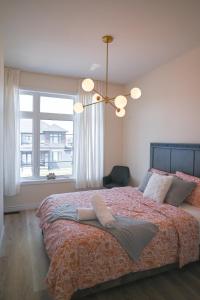 ein Schlafzimmer mit einem großen Bett mit einem großen Fenster in der Unterkunft Modern 3Bed Home 10 Mins to Niagra Falls in Thorold + 33 Fotos