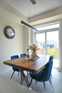 ein Esszimmer mit einem Holztisch und blauen Stühlen in der Unterkunft Modern 3Bed Home 10 Mins to Niagra Falls in Thorold