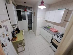 a small kitchen with white cabinets and a stove at Departamento 3 Ambientes Plaza Colon in Mar del Plata