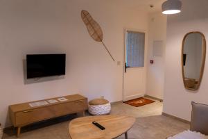 Una sala de estar con un televisor de pantalla plana en una pared. en Château de l'insolas, en Villeneuve-lès-Avignon