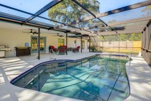 a swimming pool in a house with an open patio at Modern Coastal Escape 1 Mi to Anclote River Park in Anclote