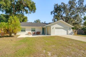 a white house with a patio and a yard at Modern Coastal Escape 1 Mi to Anclote River Park in Anclote