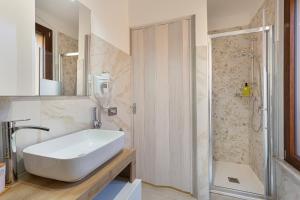 Un baño con lavabo blanco y ducha en Residence Brugnano, en Cremona