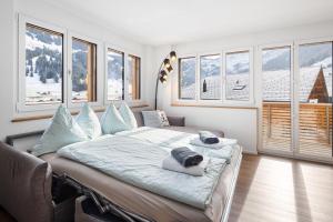 a bedroom with a large bed with pillows on it at Chuenislodge1 Neu, grosse Terrasse & Designerofen, prächtige Aussicht in Adelboden
