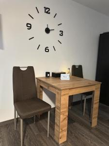 济泽罗河畔帕塞基Horský apartmán Dolní Rokytnice的桌子、椅子和墙上的时钟