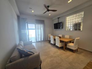 a living room with a couch and a table and chairs at Ilia Suites ''Paralia'' in Ilia