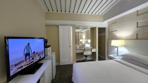 a hotel room with a bed and a flat screen tv at Palo Alto Lodge in Palo Alto +2 photos
