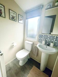 Un baño con un inodoro blanco y un lavabo. en Billing Aquadrome - Bird Lake View, en Great Billing 15 fotos más