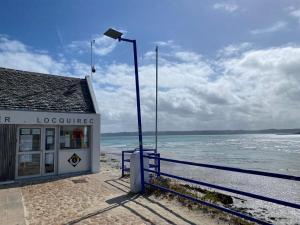 a street light next to a building on the beach at Loki Rivoli Cottage in Locquirec +10 photos