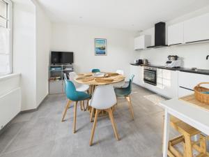 a kitchen and dining room with a table and chairs at Loki Rivoli Cottage in Locquirec