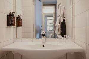 a white sink in a bathroom with a mirror at Home Hotel Magasinet in Trelleborg +58 photos