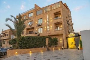un edificio con una palmera delante en Cleo Patra Pyramids Tower Inn, en Banī Ghālib