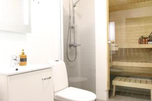 a white bathroom with a shower and a toilet at Arctic Aurora Suite Rovaniemi in Rovaniemi +7 photos