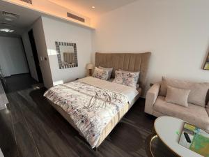a bedroom with a bed and a couch at Sea View Studio Perfect for Couples In Harbour Row in Manama +16 photos