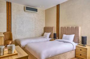 Un dormitorio con dos camas y un escritorio y una mesa. en Cleo Patra Pyramids Tower Inn, en Banī Ghālib