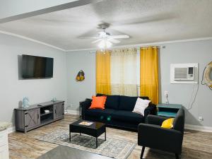 a living room with a black couch and a tv at Northeast Investments LLC in Gulfport
