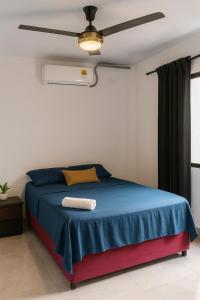 ein Schlafzimmer mit einem blau-roten Bett und einem Deckenventilator in der Unterkunft Casa Dorada in La Dorada