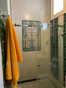eine Dusche mit gelben Handtüchern und einer Glastür in der Unterkunft la terrasse aux souvenirs in Karthago + 33 Fotos