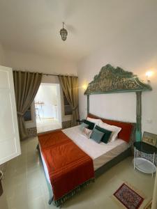 ein Schlafzimmer mit einem großen Bett mit verziertem Kopfteil in der Unterkunft la terrasse aux souvenirs in Karthago
